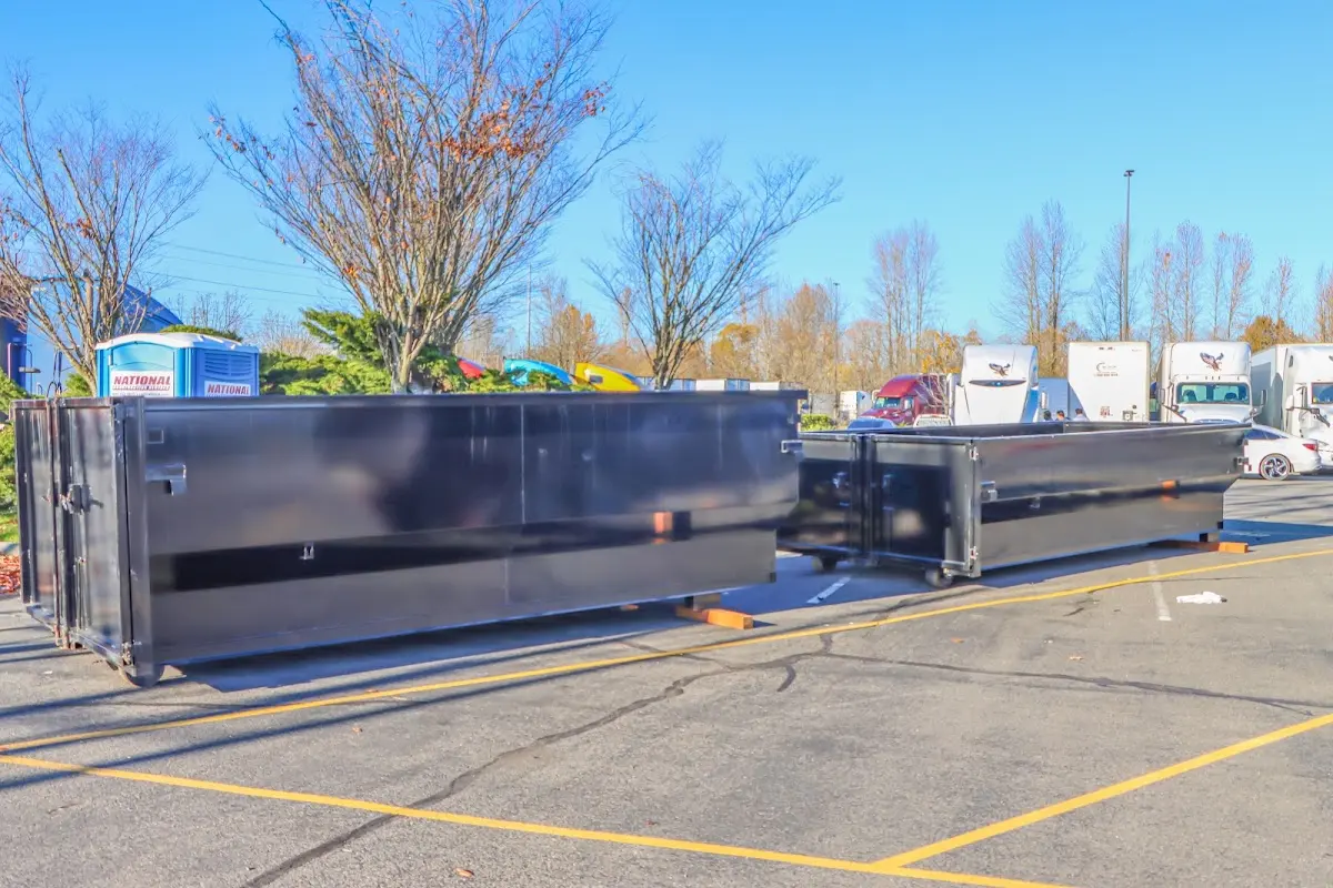 Professional dumpster rental service with roll-off container on residential driveway in Taylors